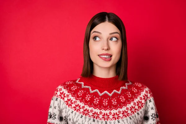 Photo de drôle douteuse jeune femme porter pull imprimé mordant lèvre regardant vide espace isolé fond de couleur rouge — Photo