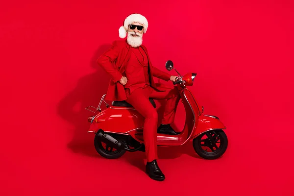 Photo de jolie charmante motocycliste mature habillé chapeau costume de Noël souriant isolé fond de couleur rouge — Photo