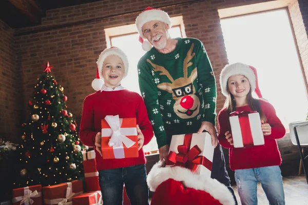 Portrait d'une jolie belle famille gaie passant Eve Noel portant des chapeaux tenant des cadeaux boîtes cadeaux à la maison loft maison à l'intérieur — Photo