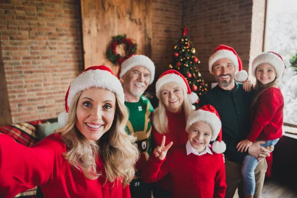 Selbstporträt von netten attraktiven fröhlichen Sohn der Familie Tochter verbringen Eve Noel mit Hüten zeigt V-Zeichen zu Hause Loft House drinnen — Stockfoto