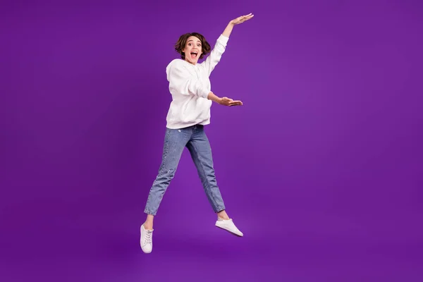 Фотографія повного розміру молодої збудженої усміхненої кричущої дівчини, що стрибає вимірюючи розмір ізольовано на фіолетовому кольоровому фоні — стокове фото