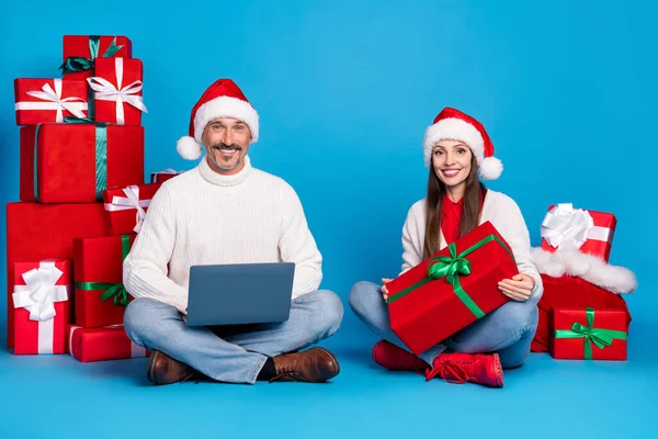 Porträtt av vackra vackra glada par med bärbar dator leverera presentaskar ordning önskan isolerad över klarblå färg bakgrund — Stockfoto