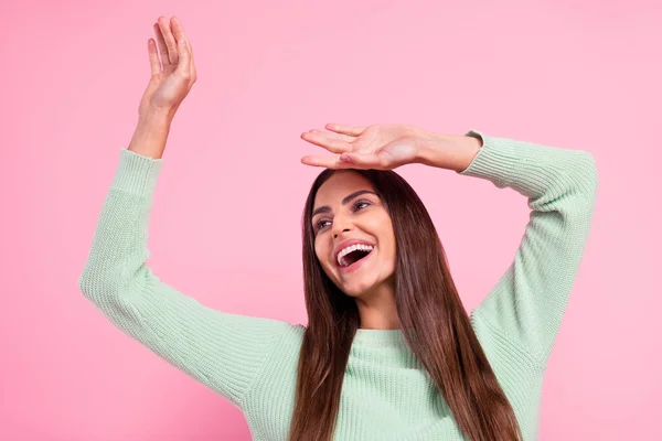 Photo of cute young brunette lady look empty space wear green pullover isolated on pink color background — Stock Photo, Image