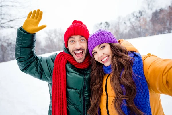 Foto av unga glada par glad positiv leende gör selfie våg hand hej semester snöig park — Stockfoto