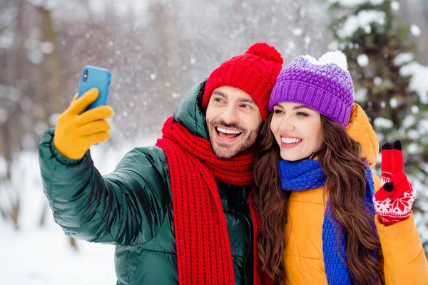 Foto von jungen Eheleuten glücklich positives Lächeln zeigen Frieden cool V-Zeichen machen Selfie Smartphone Urlaub Schneefall draußen — Stockfoto