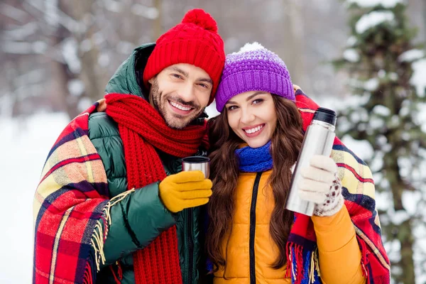 Φωτογραφία από χαριτωμένο γοητευτικό ζευγάρι γάμο φορούν παρμπρίζ πίνοντας ζεστό καφέ που καλύπτει κουβέρτα περπάτημα χιονισμένο καιρό έξω από το πάρκο — Φωτογραφία Αρχείου