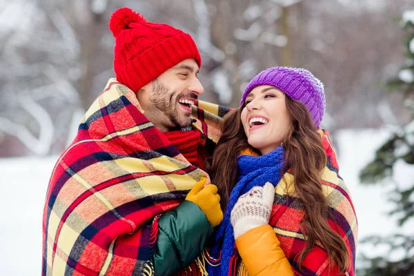 Φωτογραφία από αξιολάτρευτο αστεία φίλη φίλος ντυμένα γιλέκα που καλύπτουν καρό πάπλωμα γέλιο αγκαλιάζει το περπάτημα χιόνι σε εξωτερικούς χώρους δάσος — Φωτογραφία Αρχείου