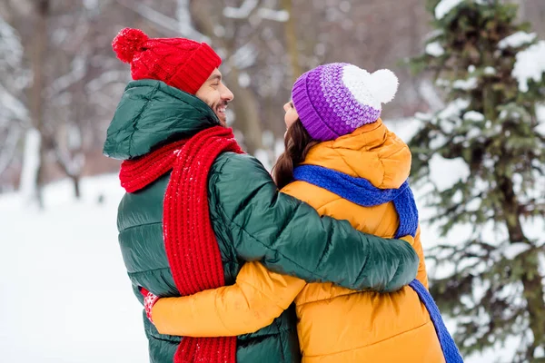 Foto av bedårande söt flickvän pojkvän klädd västar leende kramar ser varandra njuter promenader snö utomhus skog — Stockfoto