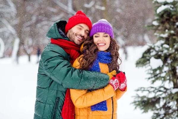 Foto av glänsande drömmande flickvän pojkvän klädd västar leende kramar njuter promenader snö utomhus skog — Stockfoto