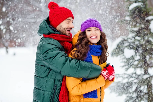 Φωτογραφία από γοητευτικό αστείο ζευγάρι γάμο φορούν παρμπρίζ περπάτημα χιονισμένο καιρό αγκαλιά χαμογελώντας έξω από το πάρκο — Φωτογραφία Αρχείου