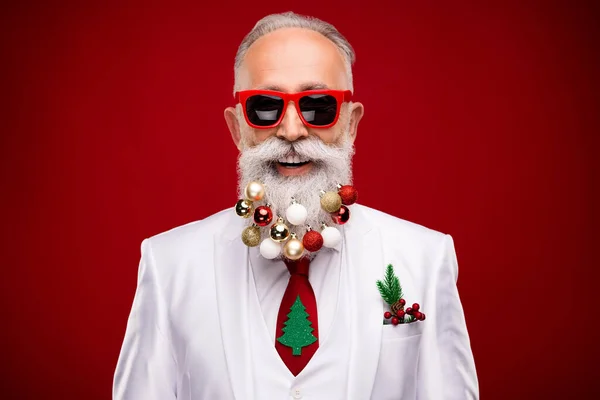 รูปภาพของผู้สูงอายุตลกผมขาวลูกชายซานต้าบนเคราสวมแว่นตาสีขาวแจ็คเก็ตแยกกันบนพื้นหลังสีแดง — ภาพถ่ายสต็อก