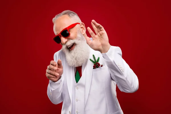 Photo de heureux funky positif vieil homme porter des lunettes de soleil danse noël showman isolé sur fond de couleur rouge — Photo