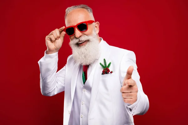 Photo de positif joyeux heureux vieil homme pointeur doigt vous cool porter présentateur sunlgass isolé sur fond de couleur rouge — Photo