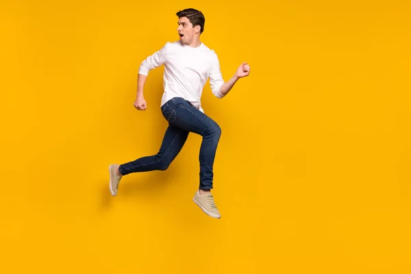 Full Size Profilfoto von Angst Brunet Millennial Kerl laufen tragen Hemd Jeans Turnschuhe isoliert auf gelbem Hintergrund — Stockfoto