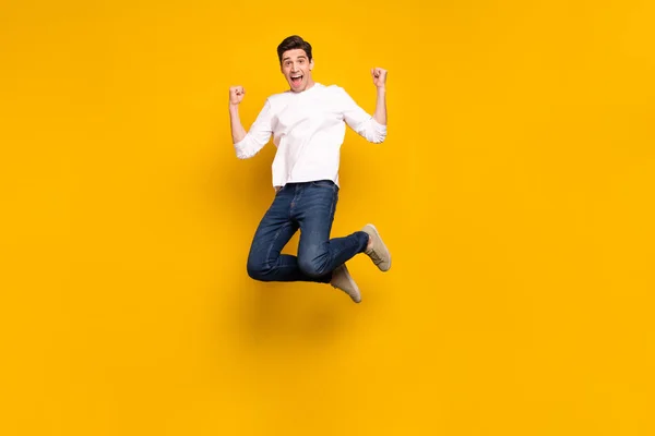 Comprimento total tamanho do corpo foto homem gesticulando como vencedor saltando para cima isolado vívido cor amarela fundo — Fotografia de Stock