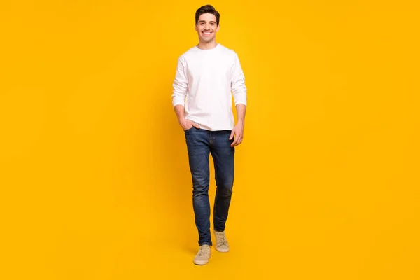 Full längd kropp storlek foto brunett kille i casual outfit ler säker promenader framåt isolerad levande gul färg bakgrund — Stockfoto