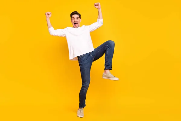 Full size foto van hooray brunet millennial man dragen shirt jeans sneakers geïsoleerd op gele kleur achtergrond — Stockfoto