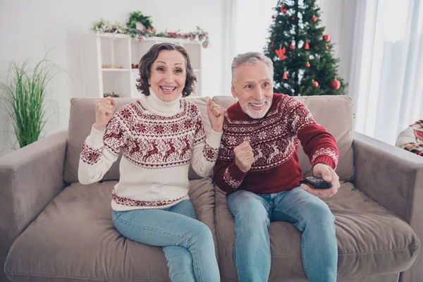 フォトのフォトのhoorayカップル高齢者女性座って見ますテレビ着用セータージーンズにホーム — ストック写真
