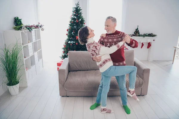 Foto de larga duración de pareja divertida anciana hombre danza desgaste suéter jeans calcetines en casa —  Fotos de Stock