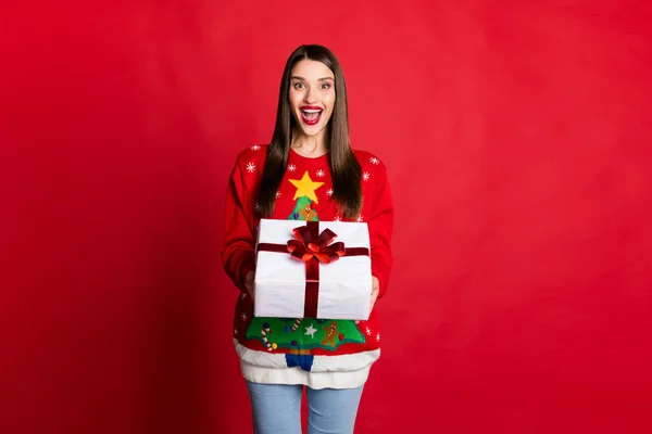 Foto di stupito felice bella giovane donna tenere per mano grande regalo scatola eccitato presente isolato su sfondo di colore rosso — Foto Stock