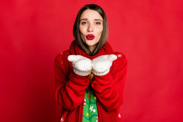 Fotografie okouzlující pěkné pozitivní mladá žena poslat vzdušný polibek ruce nosíte rukavice šála izolované na červeném pozadí — Stock fotografie