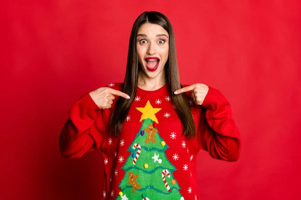 Foto di bruna affascinante stupito giovane donna punta dita maglione albero ornamento isolato su sfondo di colore rosso — Foto Stock