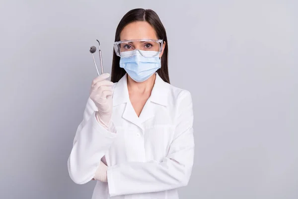 Foto de protección de la mujer madura máscara médica gafas celebrar estomatología herramientas clínica aislada sobre fondo de color gris — Foto de Stock