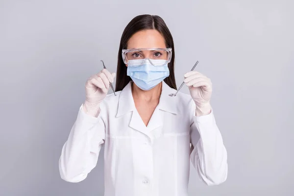 Foto de la mujer madura dentista comprobar el cuidado oral herramientas estomatológicas cavidad aislada sobre fondo de color gris — Foto de Stock