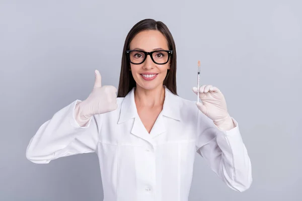 Πορτρέτο του ελκυστικού χαρούμενος γιατρός κάνει ένεση δείχνει μικρογραφία απομονώνονται σε γκρι φόντο παστέλ χρώμα — Φωτογραφία Αρχείου