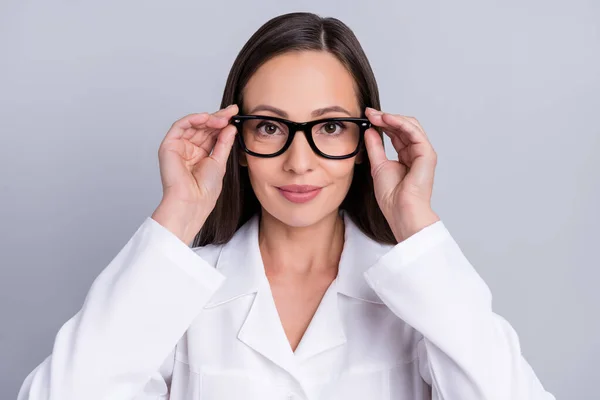 自信に満ちた陽気な女性の医者の服を着た白い腕の眼鏡笑顔隔離された灰色の背景 — ストック写真