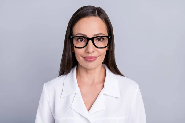 Olgun bir kadının fotoğrafı. Mutlu gülümseyen doktor kliniği. Gri renkli arka planda izole edilmiş gözlük takıyor. — Stok fotoğraf