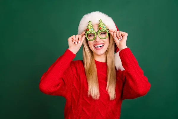 Foto portrét blondýny žena v Santa klobouk smějící se nosí legrační brýle izolované zelené pozadí — Stock fotografie
