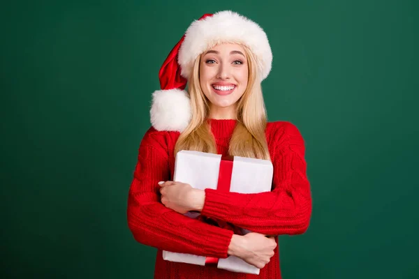 Фото позитивної чарівної щасливої молодої жінки обіймає подарункову коробку Різдвяний свято ізольовано на фоні зеленого кольору — стокове фото