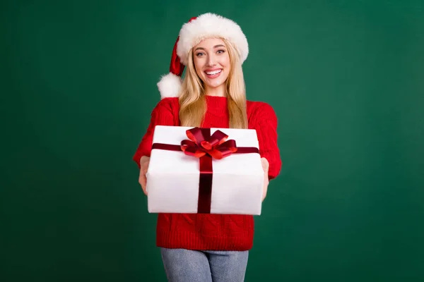 Foto retrato mujer rubia en sombrero de santa sonriente dando presente caja en xmas aislado color verde fondo — Foto de Stock