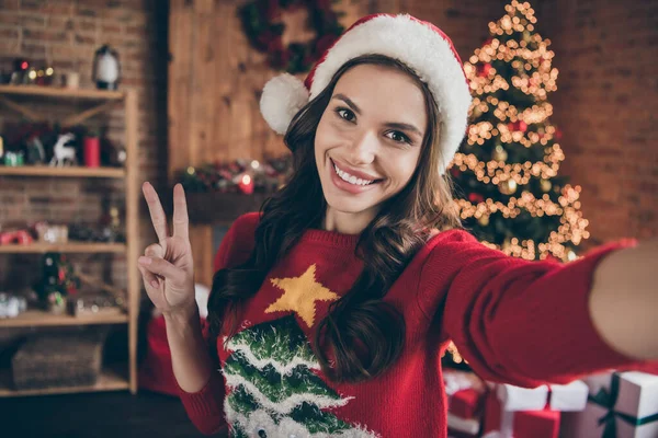 Foto de la joven y divertida dama morena hacer selfie show v-sign wear sweater hat in home alone — Foto de Stock