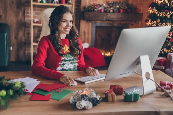 Foto av drömmande söt ung kvinna klädd tryck pullover skriva modern gadget leende inomhus rum hem hus — Stockfoto