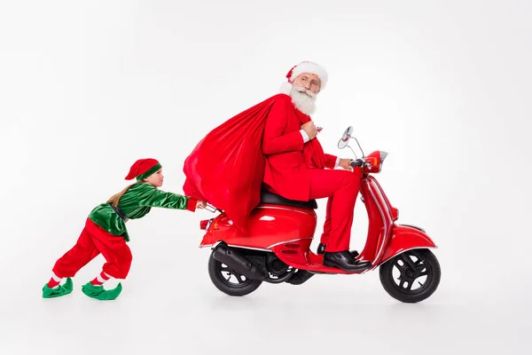 Foto de pessoas da equipe velhote passeio scooter segurar saco garoto empurrar desgaste santa elfo traje isolado cor cinza fundo — Fotografia de Stock