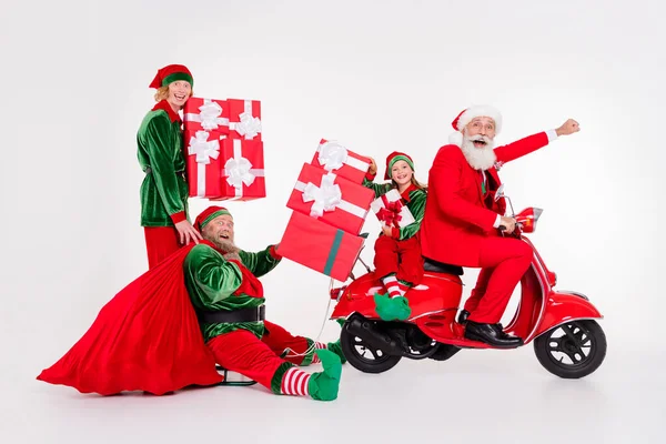 Photo of four teammates people ride scooter sleigh hold sack gifts wear santa elf costume isolated grey color background — Stock Photo, Image