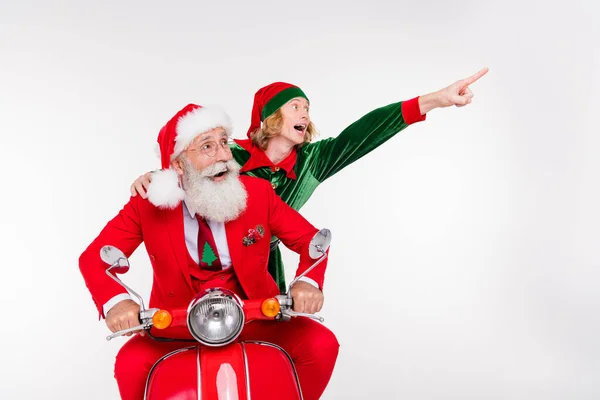 Foto de duas pessoas do partido passeio bicicleta dedo direto vazio espaço desgaste santa elfo traje isolado cor branca fundo — Fotografia de Stock