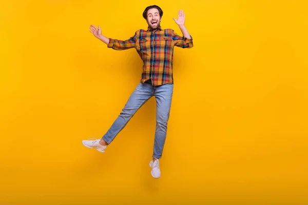 Full length φωτογραφία του αστείου brunet Millennial τύπος άλμα φορούν πουκάμισο τζιν sneakers απομονώνονται σε κίτρινο φόντο — Φωτογραφία Αρχείου