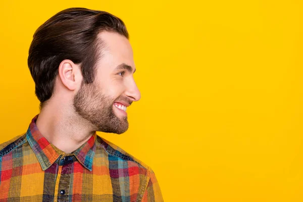 단짝이고 잘생긴 젊은 남자가 체크무늬 셔츠를 입고 빈 공간으로 보이며 누런 노란 배경을 웃고 있는 사진 — 스톡 사진