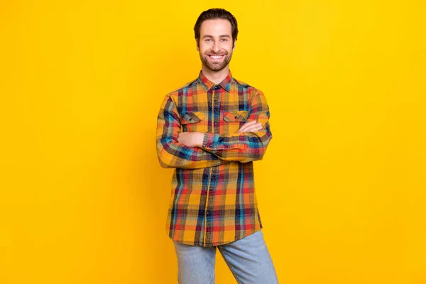 Zdjęcie uroczy pewny siebie młody człowiek nosić koszulę w kratę uśmiechnięte ręce złożone odizolowany żółty kolor tła — Zdjęcie stockowe