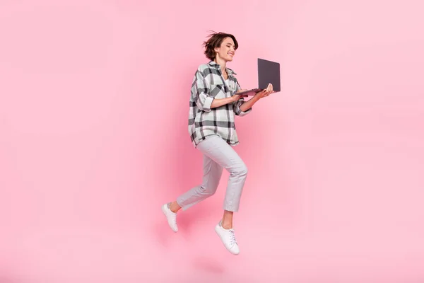 Perfil de corpo inteiro foto lateral da jovem mulher feliz sorriso positivo salto uso laptop isolado sobre cor rosa fundo — Fotografia de Stock