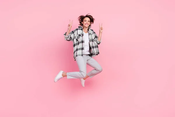 행복 한 긍정적 인 미소를 짓는 젊은 여성의 전신 사진은 핑크 색 배경 위로 분리 된 평화멋진 v-sign 점프를 보여준다. — 스톡 사진