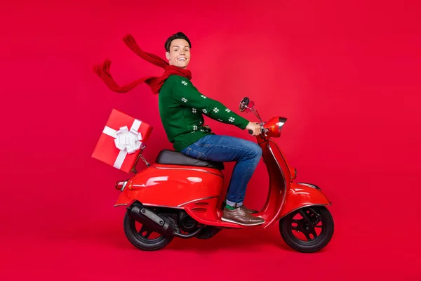 Πλήρες μήκος σώματος μέγεθος φωτογραφία χαμογελαστός τύπος κάθεται σε ποδήλατο στο κασκόλ οδήγησης σκούτερ απομονωμένο ζωντανό κόκκινο χρώμα φόντο — Φωτογραφία Αρχείου