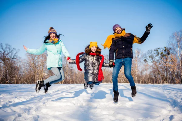 Pleine photo du corps de drôle belle famille saut porter tissu d'hiver à l'extérieur marcher dans le parc — Photo