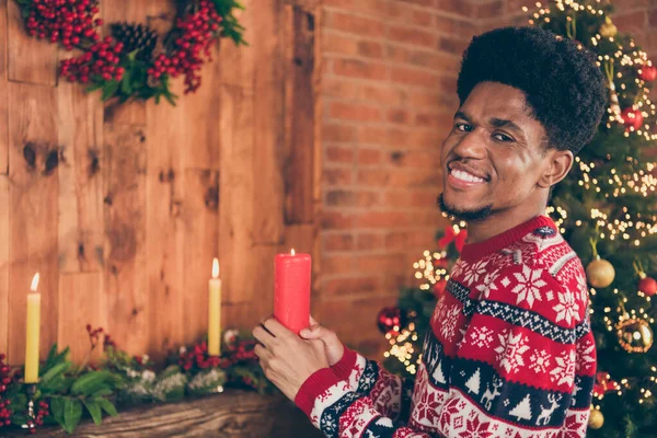Φωτογραφία άνθρωπος πορτρέτο κρατώντας κερί διακόσμηση apartmant πριν από Χριστούγεννα χαμογελώντας φορώντας πουλόβερ με στολίδι — Φωτογραφία Αρχείου