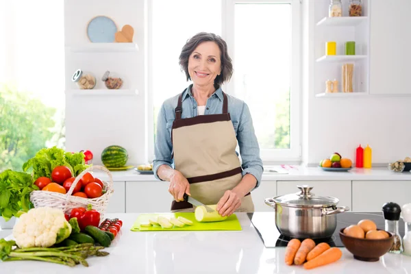 Фото веселої позитивної старої жінки посміхається гарний настрій зрізані овочі посміхаються в приміщенні всередині домашньої кухні — стокове фото