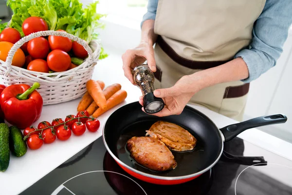 Foto ritagliata di donna matura cucinare carne indossare jeans grembiule camicia in cucina da solo — Foto Stock