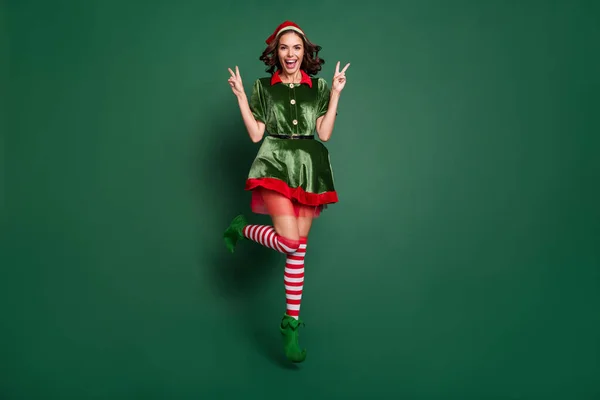 Full längd kroppsstorlek bild av ganska trendiga glada flicka hoppning visar v-tecken isolerad över grön färg bakgrund — Stockfoto